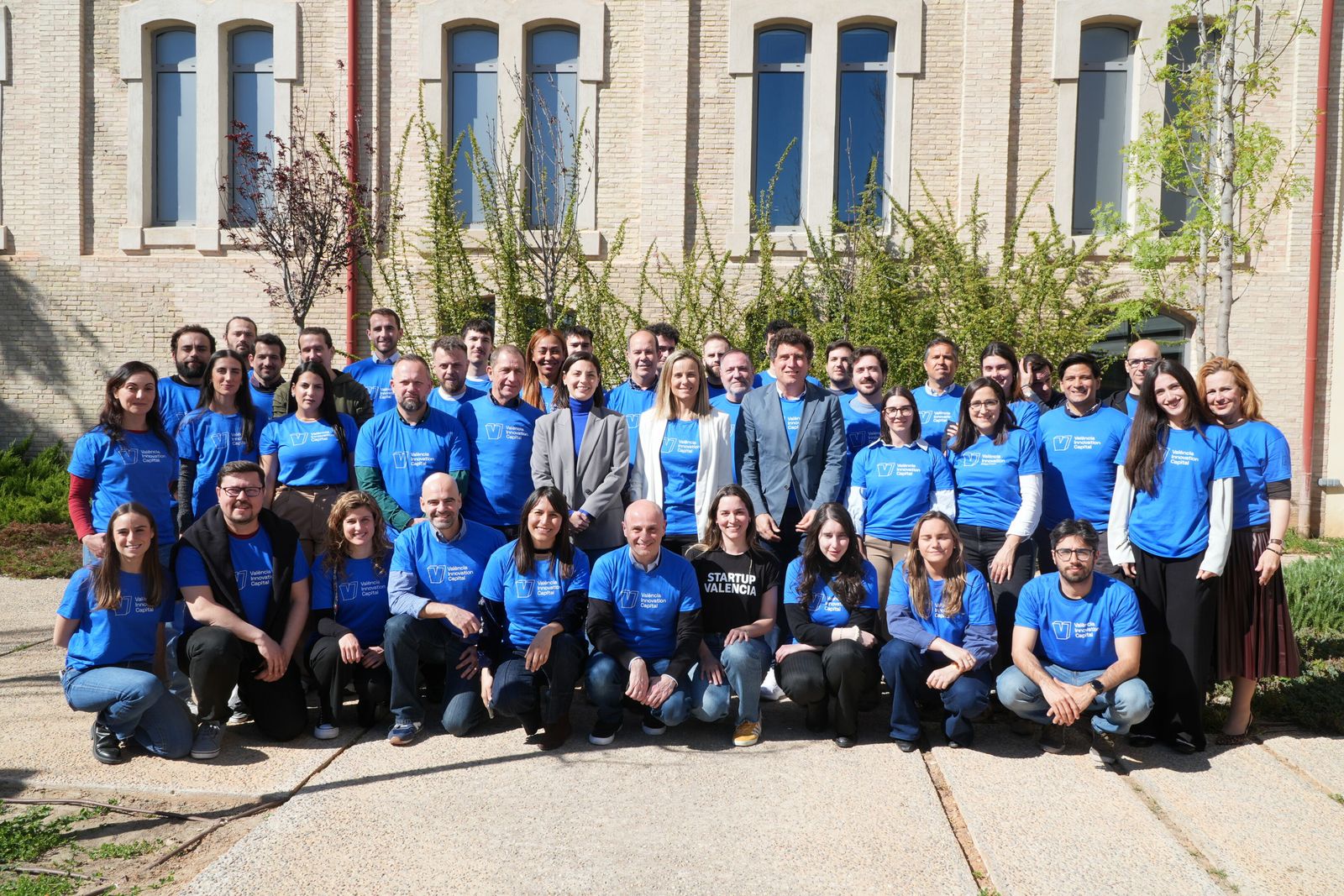 Foto de grupo de las startups y el equipo de València Innovation Capital con camisetas azules en un patio